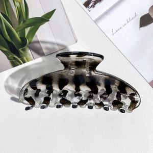 Detailed view of a leopard print hair claw clip with a glossy finish and multi-tooth design