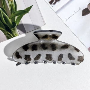 Detail of leopard print acetate hair claw clip on aesthetic stationery background