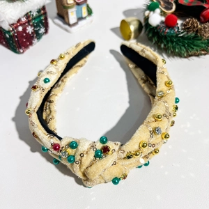 Detail eines Weihnachts-Knoten-Haarreifens mit festlichen Perlen auf Samtstoff
