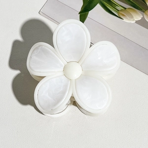 Detailansicht der cremefarbenen Haarklammer in Blumenform mit edler Marmortextur