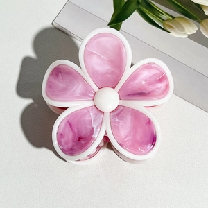 Nahaufnahme der cremefarbenen Blumen-Haarklammer mit rosa Marmor-Textur