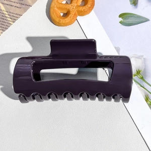 Detail of dark purple soft silicone hair claw clip showing smooth finish and open design