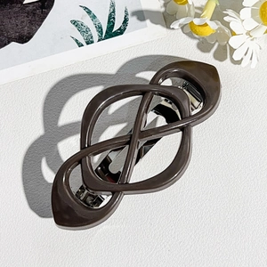 Close-up of brown geometric hollow spring hair clip with a glossy resin finish