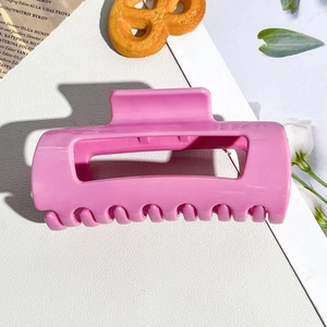 Detailed view of glossy pink soft silicone hair claw clip on a stylish lifestyle background