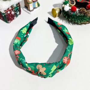 Nahaufnahme von grünem Stoff-Weihnachtshaarreif mit festlichen Lebkuchenmann-Mustern