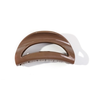 Polished brown semicircular shark hair claw clip with cutout design on white background