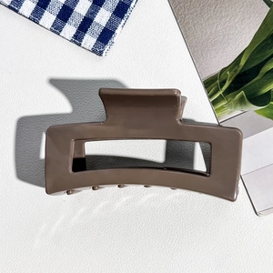 Détail de la pince à cheveux carrée de 8,5 cm en silicone marron foncé sur fond blanc