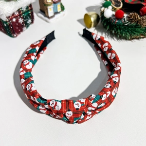 Detail eines roten karierten Schneemann-Haarreifens mit festlicher Weihnachtsdekoration
