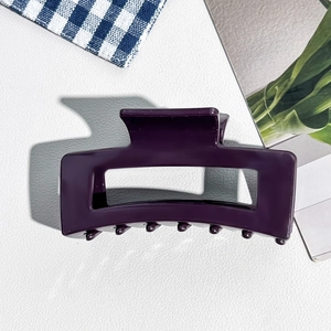 Détail d'une grande pince à cheveux violet foncé en silicone au design rectangulaire