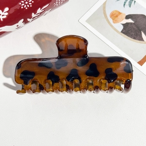 Macro detail of amber tortoise shell hair claw clip with elegant acetate texture