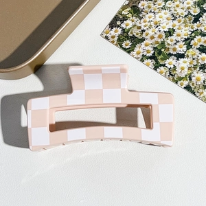 Detailaufnahme einer mittelgroßen Haarklammer mit Karomuster in Rosa und Weiß
