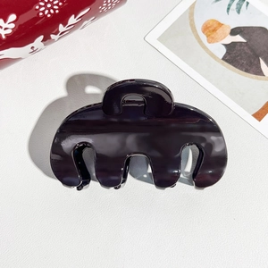 Macro detail of glossy dark purple claw clip with resin finish for half-up hairstyles