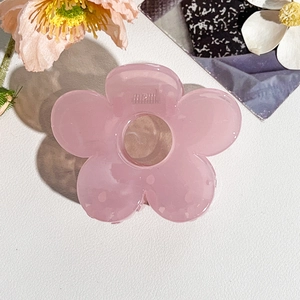 Dettaglio del fermaglio per capelli a fiore rosa in acrilico opaco con petali forati