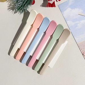 Close-up of 6-piece colorful plastic spatulas for cosmetics on a festive background