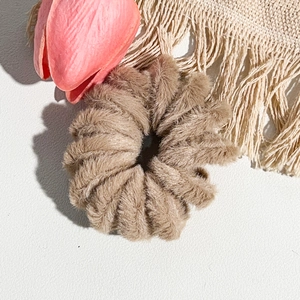 Gros plan d'un chouchou en peluche marron à motif léopard avec une texture douce et veloutée