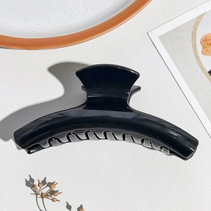 Vista macro di una pinza per capelli in silicone nero lucido con finitura liscia e denti