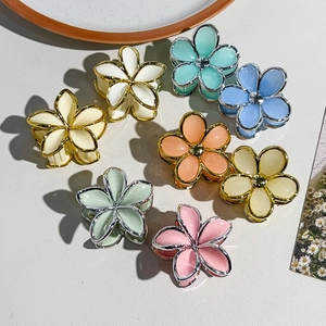 Flat lay of small floral hair claw clips with gold trim in eight soft pastel jelly colors