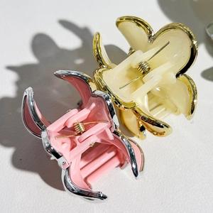 Detail view of pink and cream floral hair claws with metallic gold and silver edging