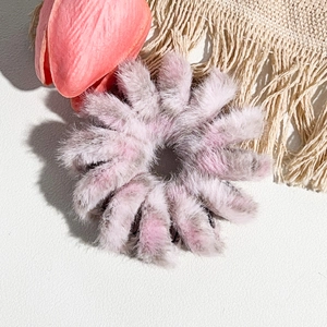 Vue détaillée du chouchou fleur en fausse fourrure douce aux tons rose et violet poudré