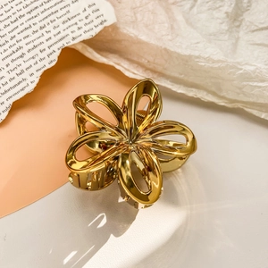 Detailed macro shot of a golden hollow plumeria flower metal hair claw clip accessory