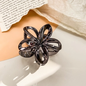 Detail of hollow plumeria flower metal hair claw with gun black electroplated finish