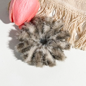 Gros plan d'un chouchou gris en fausse fourrure montrant une texture douce et pelucheuse