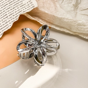 Detailed close-up of a silver hollow plumeria hair claw clip with mirror finish