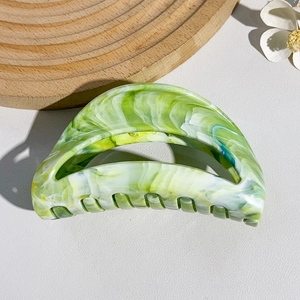 Detail of green and white marbled hair claw clip with strong teeth for thick hair