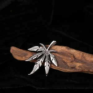 Vintage stainless steel maple leaf pendant with rustic texture on black velvet
