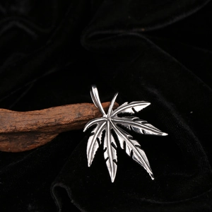 Macro shot of vintage stainless steel cannabis leaf pendant with detailed leaf veins