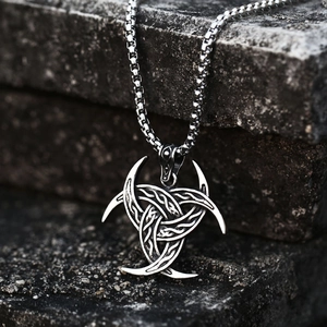 Macro detail of Nordic Odin horns pendant with antique finish on stone background