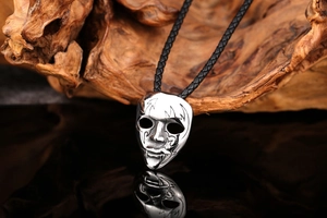 Macro view of a Gothic opera mask pendant with flame motifs on natural wood background