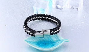 Détail du bracelet en cuir tressé noir pour hommes avec chaîne argentée sur fond de glace