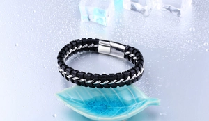 Détail macro du bracelet tressé pour homme en cuir noir et acier inoxydable à fermoir magnétique