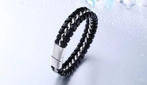 Détail d'un bracelet pour homme en cuir tressé noir avec chaîne en métal et fermoir poli
