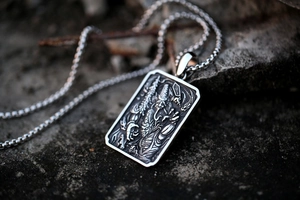 Macro shot of gothic style relief engraving on vintage stainless steel pendant necklace