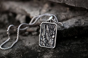 Detailed macro view of vintage stainless steel tag pendant with embossed folklore figures