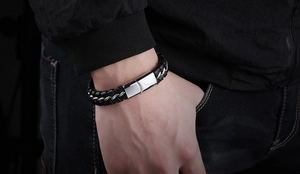 Détail du bracelet tressé en cuir noir pour homme avec chaîne en acier et fermoir poli