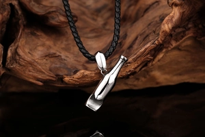 Vue macro d'un pendentif en forme de bouteille en acier poli sur un cordon en cuir