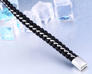 Détail d'un bracelet tressé en cuir noir avec chaîne en acier et fermoir poli
