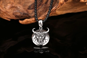Detail of vintage stainless steel bull head pendant on a black woven leather cord necklace
