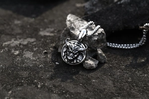 Macro shot of vintage bull head embossed round pendant necklace in rustic steel finish