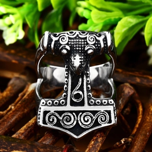Macro shot of Viking Mjolnir ring detail with vintage engraved patterns on a wooden base