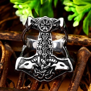 Macro view of vintage stainless steel Viking Mjölnir ring with intricate Norse carvings