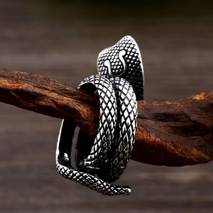 Macro shot of vintage cobra snake ring with detailed scales on a natural wood branch