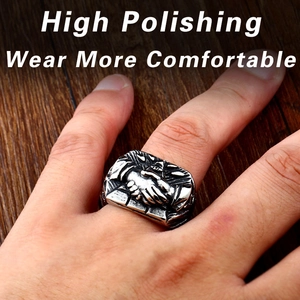 Detailed view of vintage steel handshake ring with high polished finish on wood background