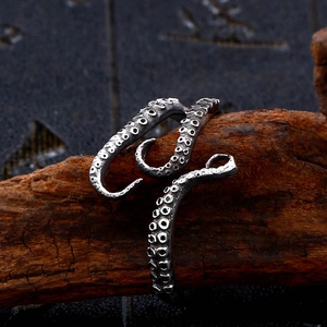Close-up of vintage silver octopus tentacle ring with detailed suction cup texture on wood