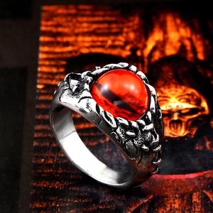Gros plan sur la bague punk œil du diable avec pierre rouge et texture d'os
