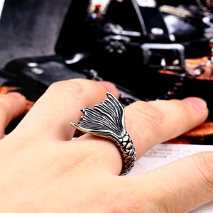 Vintage stainless steel ring with detailed fish tail design worn on index finger