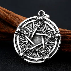 Vintage stainless steel Viking star pendant with intricate floral patterns on natural wood